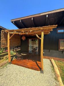 a wooden deck with a bench and a pergola at Tiny House 3 En el río in Linares