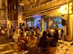 a crowd of people sitting outside a restaurant at night at Casa Blu in Šibenik
