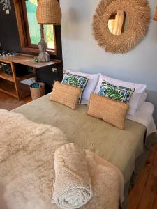 a bedroom with a bed with pillows and a mirror at Tiny House 3 En el río in Linares +14 photos