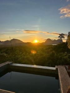a swimming pool with the sunset in the background at VISTA Cadlao in El Nido Airport