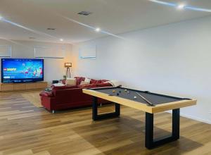 a living room with a pool table and a couch at 10 Jefferson Court in Wellington East