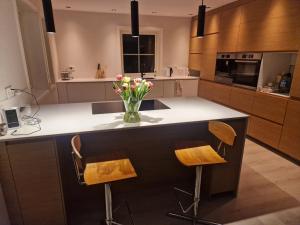 a kitchen with a counter with a vase of flowers on it at Villa Modum in Skreppen +77 photos
