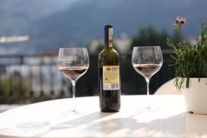 a bottle of wine and two wine glasses on a table at Guesthouse Alemannia in Berat