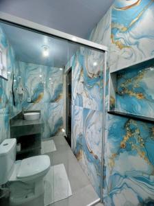 a bathroom with a toilet and a wall mural at Lar dos Lençóis BHS in Barreirinhas +57 photos