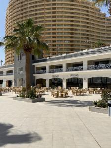 a building with tables and chairs and a palm tree at Porto Sokhna Penthouse with Private Pool - MR in Ain Sokhna