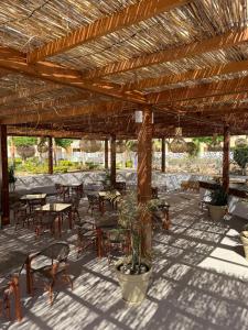 a patio with tables and chairs under a wooden pergola at Porto Sokhna Penthouse with Private Pool - MR in Ain Sokhna