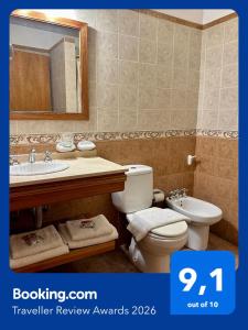a bathroom with a sink and a toilet and a mirror at Hotel Sans Souci in Belén de Escobar