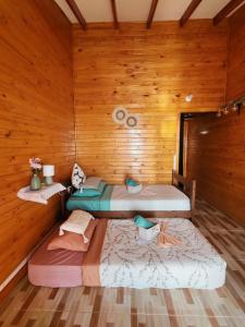 three beds in a room with wooden walls at Pieza con vista al mar in La Serena