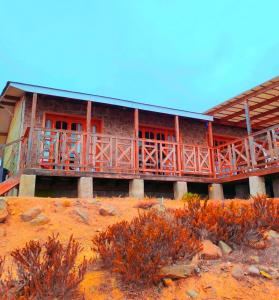 a wooden house with a balcony on top of a hill at Pieza con vista al mar in La Serena
