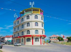un bâtiment blanc et rouge avec un panneau sur celui-ci dans l'établissement Mirador Hotel, à Corozal Town