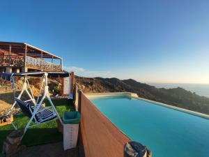 a swimming pool with swings and the ocean in the background at Pieza con vista al mar in La Serena