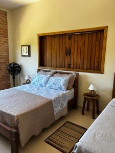 a bedroom with a large bed with blue pillows at Pousada Acordes do Lago in Cunha