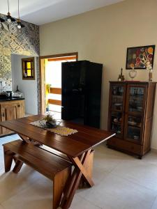 a kitchen with a wooden table and a black refrigerator at Pousada Acordes do Lago in Cunha