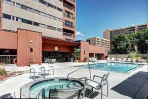 a swimming pool with chairs and a building at Comfortable 1 Bed 1 Bath Loft in Uptown Denver in Denver