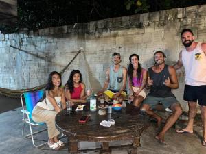a group of people sitting around a table at Pipa Roots Hostel in Pipa