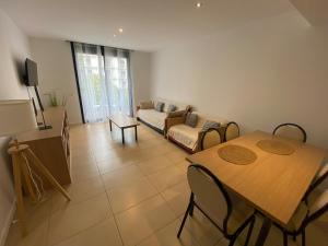 a living room with a table and a couch at Osaka Suite in Lloret de Mar +7 photos