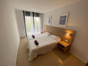 a bedroom with a bed and a large window at Osaka Suite in Lloret de Mar
