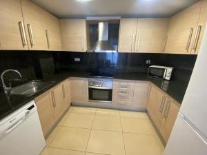a kitchen with a sink and a stove top oven at Osaka Suite in Lloret de Mar