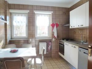 a kitchen with white cabinets and a table and chairs at La Betulla Appartamento confortevole Wifi e Parking free in Aosta