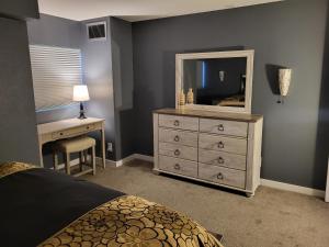 a bedroom with a dresser with a mirror and a desk at Comfortable 1 Bed 1 Bath Loft in Uptown Denver in Denver +22 photos