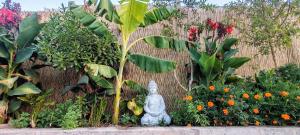a statue in a garden with flowers and a fence at Cabañas Torres del Sol in Vicuña