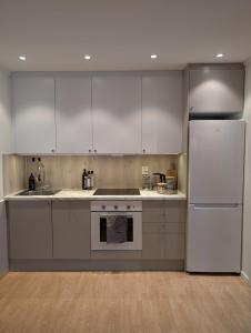 a kitchen with white appliances and a white refrigerator at Leilighet in Bjørkheim