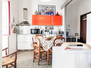 a kitchen with orange cabinets and a table with chairs at Apartment Barasteguia by Interhome in Ciboure +13 photos