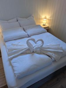a bed with two heart shaped towels on it at Leilighet in Bjørkheim
