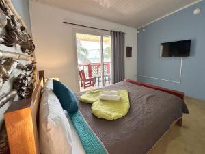 a bedroom with a bed with a television and a balcony at Guanico Beach Resort in Tonosí