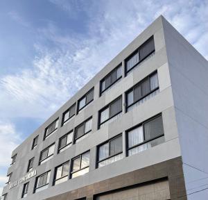 a white building with windows on the side of it at Hotel Concordia in Guadalajara