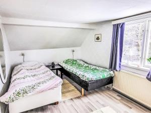 two beds in a room with a window at Villa Äppelgården by Interhome in Örebro