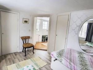 a bedroom with a bed and a chair and a mirror at Villa Äppelgården by Interhome in Örebro +9 photos