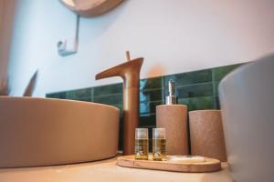 a table with two glasses and a sink and a laptop at L Escale Balinaise et Spa #7 in Agen