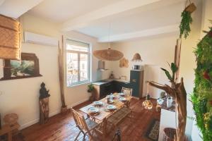 a living room with a wooden table and chairs at L Escale Balinaise et Spa #7 in Agen