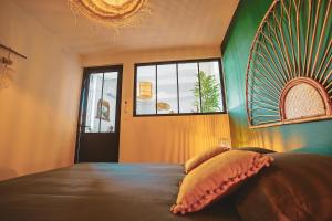 a bedroom with a large bed and a window at L Escale Balinaise et Spa #7 in Agen