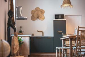 a kitchen with a sink and a table with chairs at L Escale Balinaise et Spa #7 in Agen