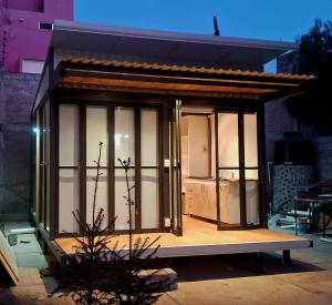 a small house with glass doors on a building at TinyHome Texcoco in San Miguel Coatlinchán