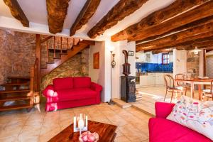 a living room with a red couch and a table at Old Stonehouse Stari San in Pinezici