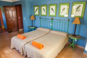 - 2 lits dans une chambre aux murs bleus dans l'établissement Caseria San Jose, à Bobadilla