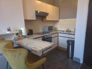 a small kitchen with a table and chairs in it at Glams one bedroom apartment in Wolverhampton +25 photos
