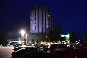 a parking lot in front of a building at night at Business Hotel Prijedor in Prijedor
