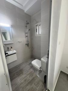 a white bathroom with a toilet and a sink at Les Sublimes Residences Tweens in Abidjan