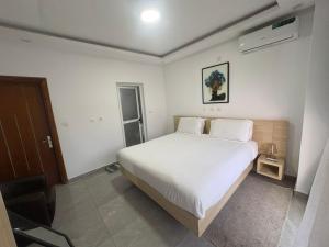 a bedroom with a large white bed and a chair at Les Sublimes Residences Tweens in Abidjan