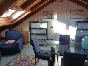 sala de estar con mesa de cristal y sillas en Appartamento Lago Maggiore, en Arona