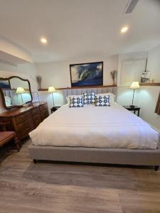 a bedroom with a large white bed with blue pillows at Rustic Guest Suite in Ucluelet