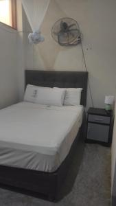 a bedroom with a bed with a fan on the wall at La casa de Joan in Máncora