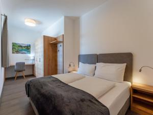 a bedroom with a large bed and a desk at Lärchenhof Top 101 in Mauterndorf +53 photos