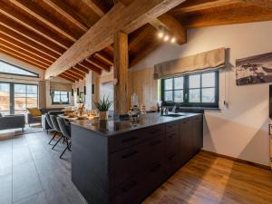 an open kitchen with wooden ceilings and a dining room at Wagrainer TauernLodge 42C in Wagrain