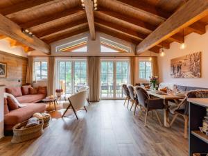 a living room with wooden ceilings and a table and chairs at Wagrainer TauernLodge 42A in Wagrain