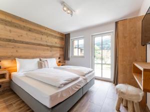 a bedroom with a large bed with a wooden wall at Wagrainer TauernLodge 42A in Wagrain